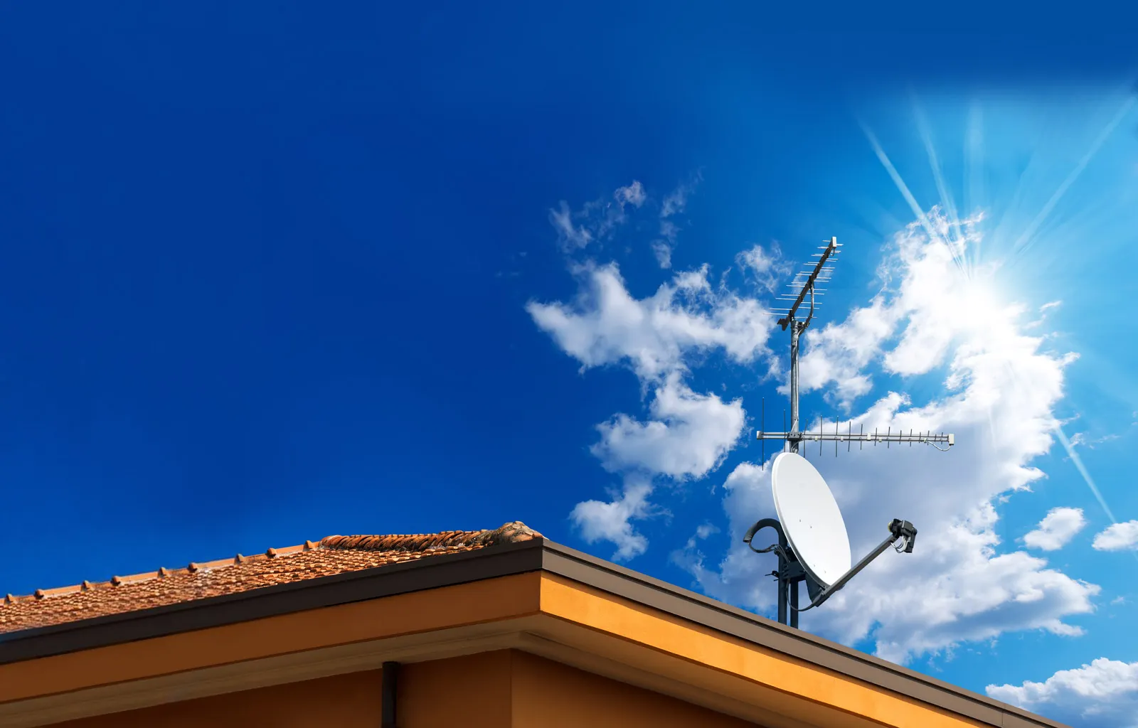 Satellite dish and TV antenna on a roof