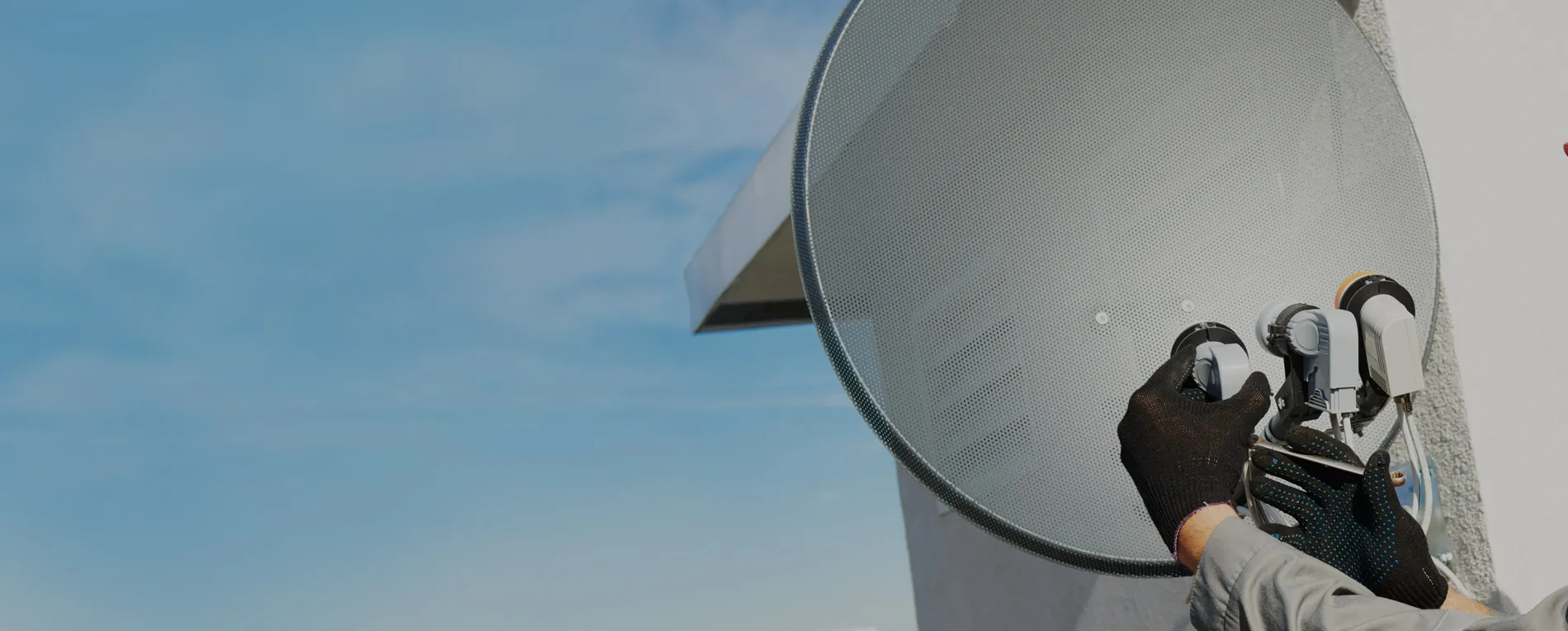 Technician aligning a satellite dish