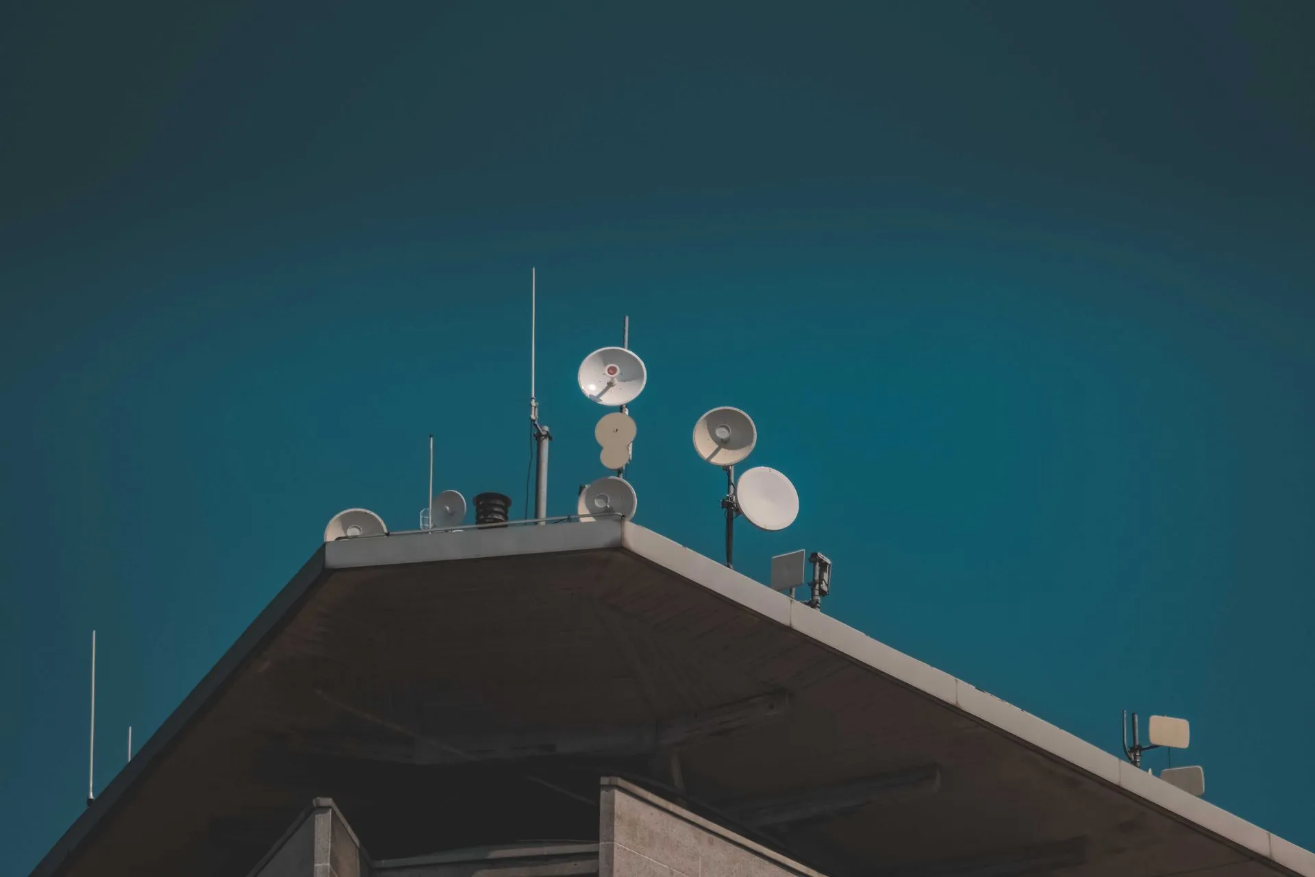 Satellite dishes and antennas on a building rooftop